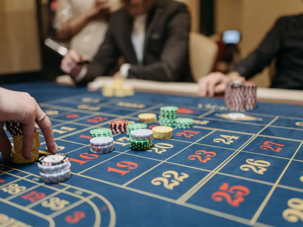 Player placing chips on a roulette table in a casino